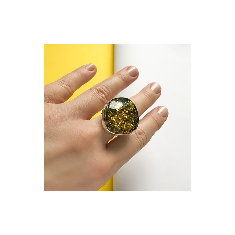 Pierścionek srebrny z dużym bursztynem w kolorze zielonym. Prosty, minimalistyczny model pierścionka.