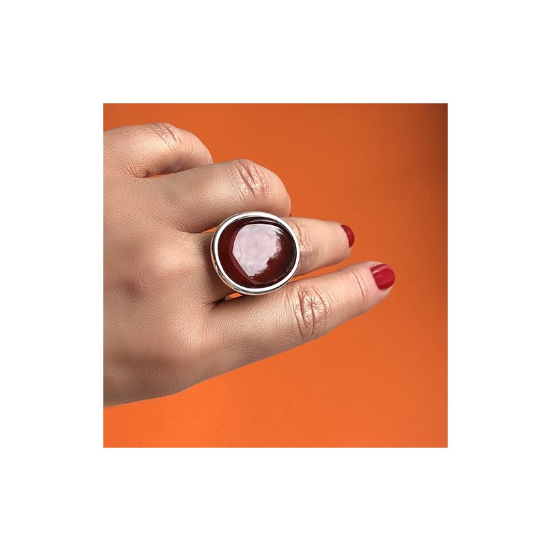 Pierścionek srebrny z wiśniowym płaskim bursztynem w prostej minimalistycznej oprawie.