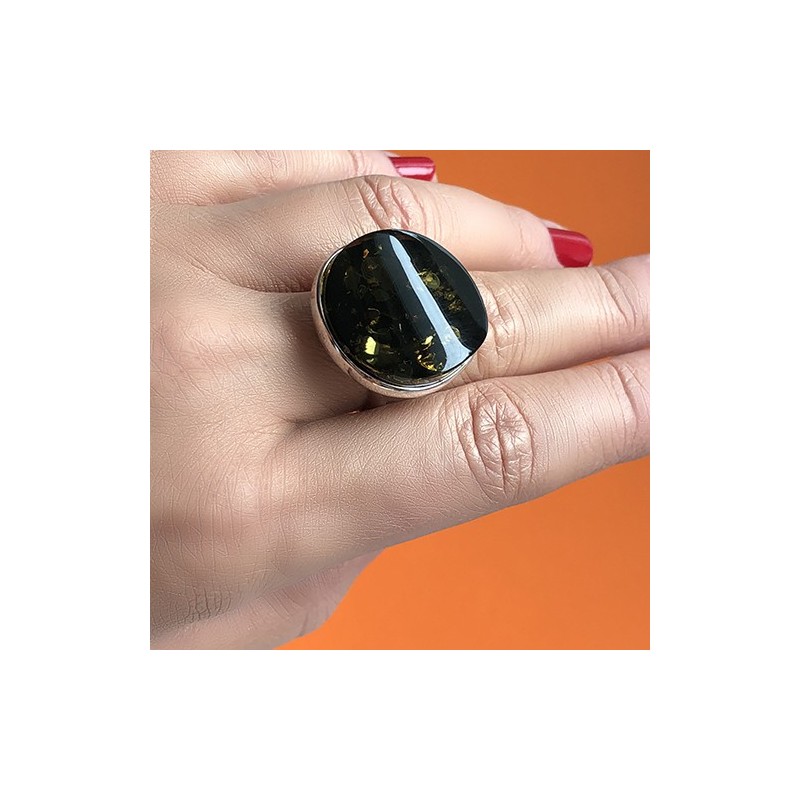 Pierścionek z dużym zielonym bursztynem wykonany ze srebra 925 w prostej oprawie.