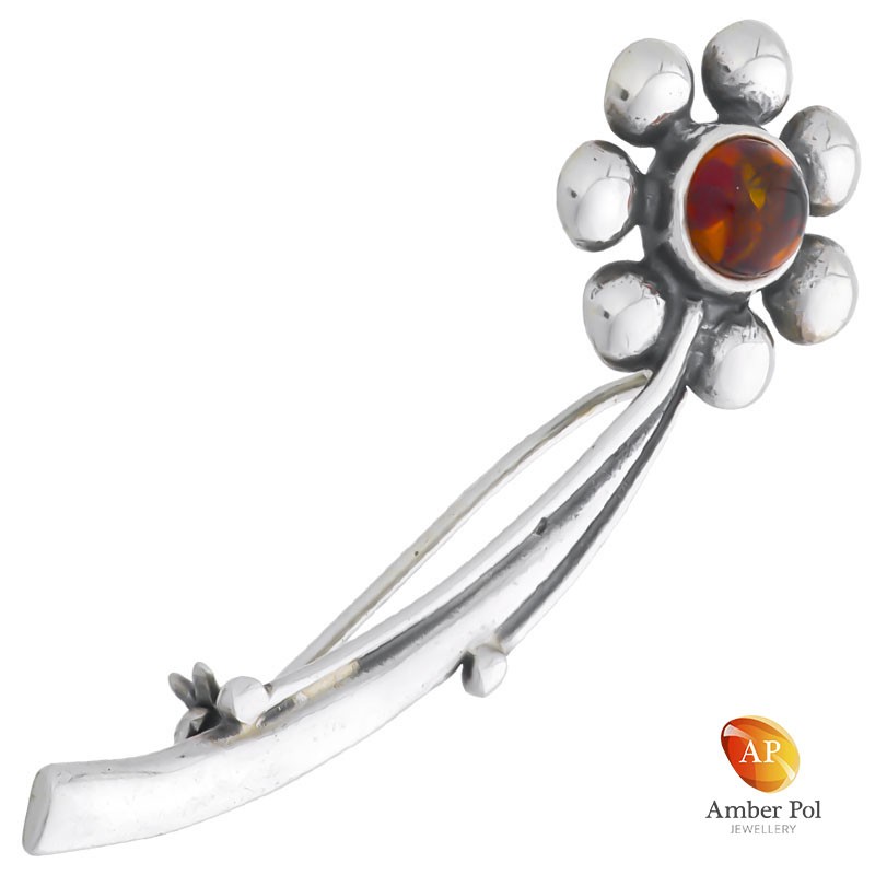 Broszka srebrna 925 z bursztynem w kolorze koniaku jako środek kwiatka otoczona srebrnymi listkami, na łodyżce.