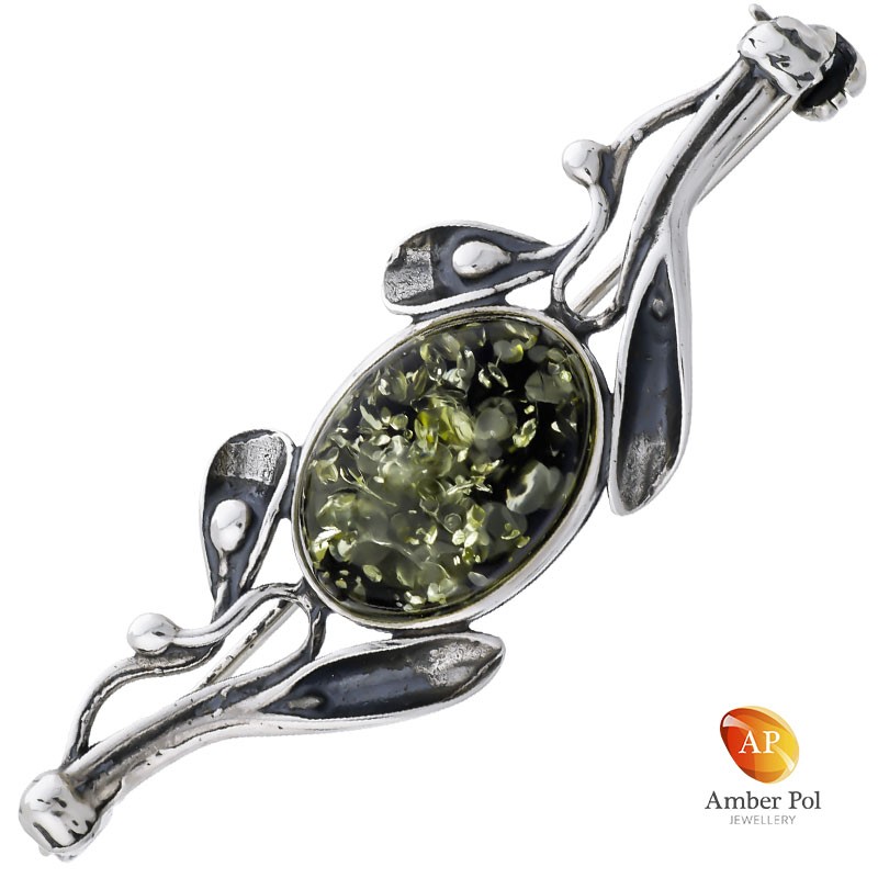 Broszka srebrna 925 z zielonym bursztynem otoczonym srebrnymi zdobieniami.