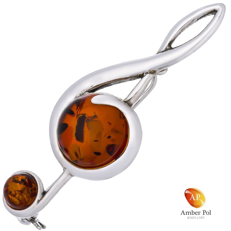 Broszka srebrna 925 z bursztynem w kolorze koniaku o kształcie klucza wiolinowego.