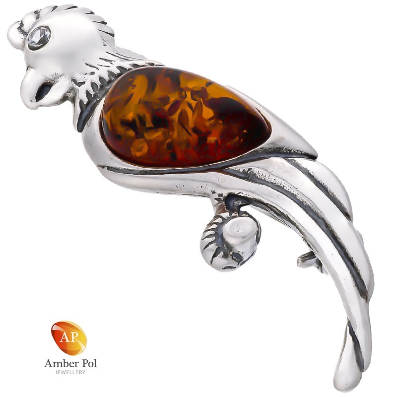 Broszka srebrna 925 o kształcie papugi z bursztynem w kolorze koniaku umieszczonym w skrzydełku jak i cyrkonii jako oczko.