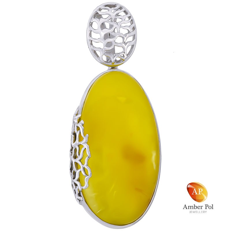 Wisior ze srebra 925 całkowicie wykonany ręcznie z naturalnym białym bursztynem oprawionym zdobieniem w formie ażurowej.