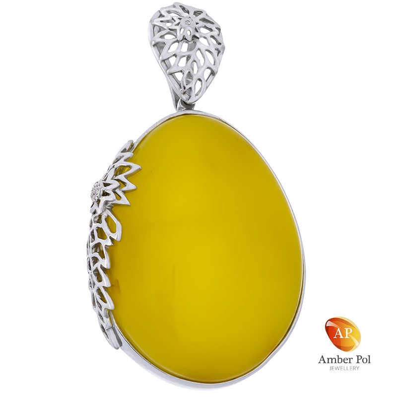 Wisior srebrny 925 z pięknym  mlecznym bursztynem wkomponowanym w stylową oprawę z ażurowymi zdobieniami.