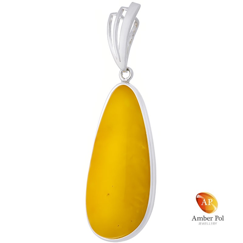 Unikatowy wisior ze srebra 925 z pięknym bursztynem w mlecznym kolorze o wydłużonej linii, całkowicie oprawionym ręcznie.