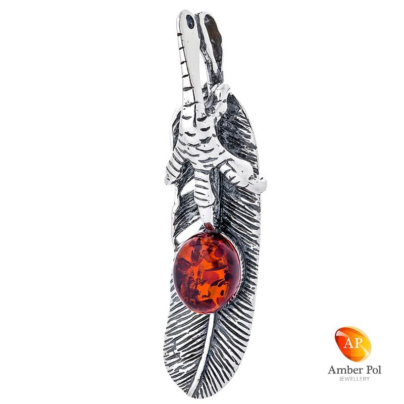 Wisiorek ze srebra próby 925 z koniakowym bursztynem umieszczonym na srebrnym piórku, przy zawieszce kształt szpona orła.
