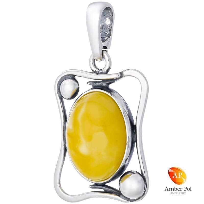 Wisior ze srebra próby 925 o kształcie nieregularnej ramki z bursztynem w mlecznym kolorze wypełniającym środek.