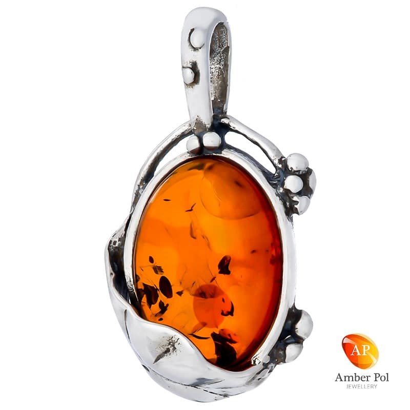 Wisior srebrny 925 z koniakowym bursztynem umieszczonym pod sporym liskiem i otoczony delikatnymi zdobieniami.