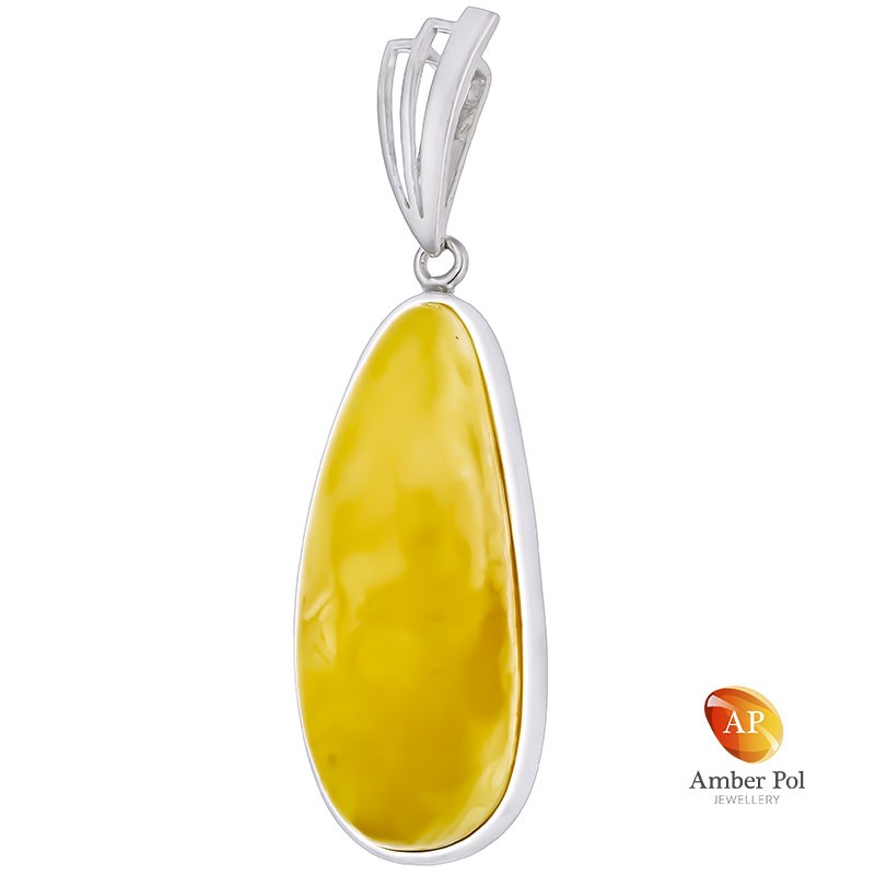 Unikatowy wisior ze srebra 925 z pięknym bursztynem w mlecznym kolorze o wydłużonej linii, całkowicie oprawionym ręcznie.