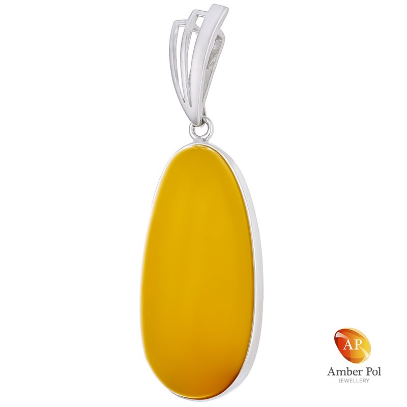 Unikatowy wisior ze srebra 925 z pięknym bursztynem w mlecznym kolorze o wydłużonej linii, całkowicie oprawionym ręcznie.