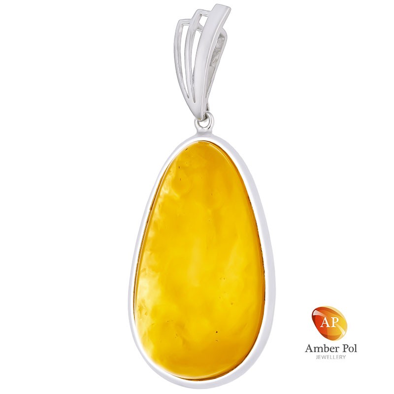 Unikatowy wisior ze srebra 925 z pięknym bursztynem w mlecznym kolorze o wydłużonej linii, całkowicie oprawionym ręcznie.