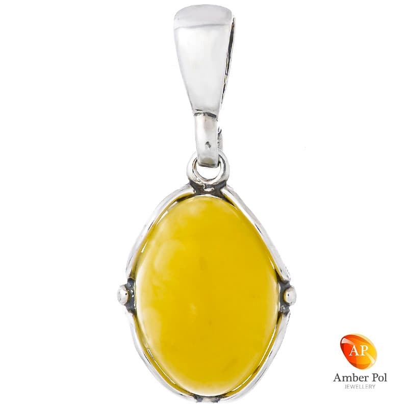 Piękny wisiorek srebrny 925 z owalnym bursztynem w białym kolorze otoczony delikatnymi bocznymi zdobieniami.