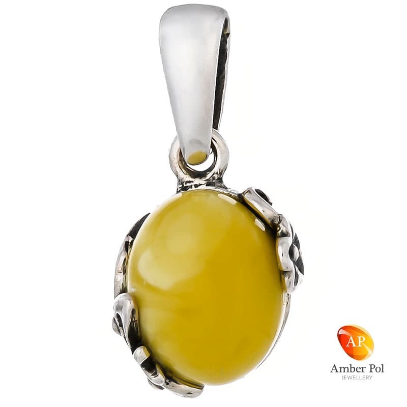 Piękny wisiorek ze srebra próby 925 z bursztynem w mlecznym kolorze i delikatnymi ażurowymi bocznymi zdobieniami.