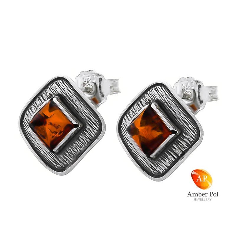 Kolczyki na sztyft kwadrat ze srebra 925 z koniakowym bursztynem zdobione powierzchniami o ciekawej fakturze.