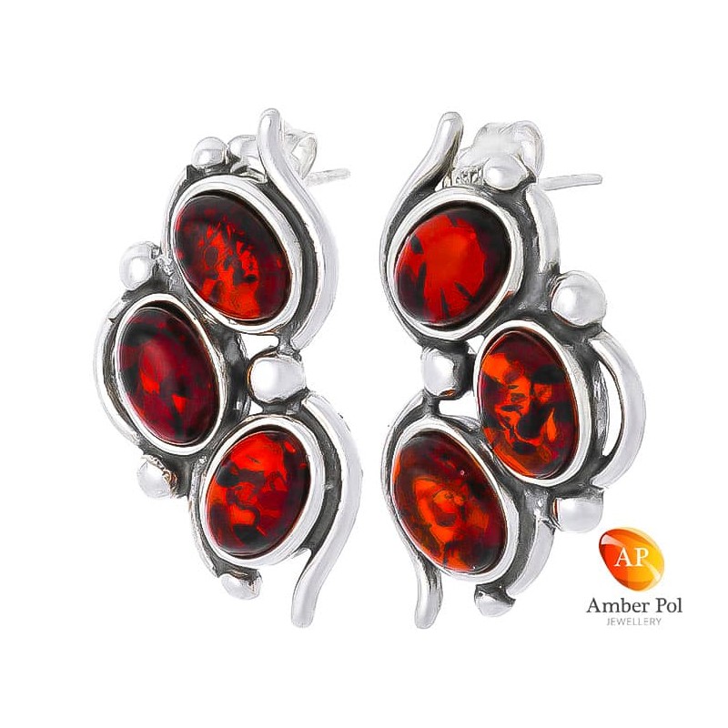 Piękne kolczyki ze srebra 925 na sztyft z trzema owalnymi bursztynami w kolorze koniaku przeplatanymi delikatnymi zdobieniami.