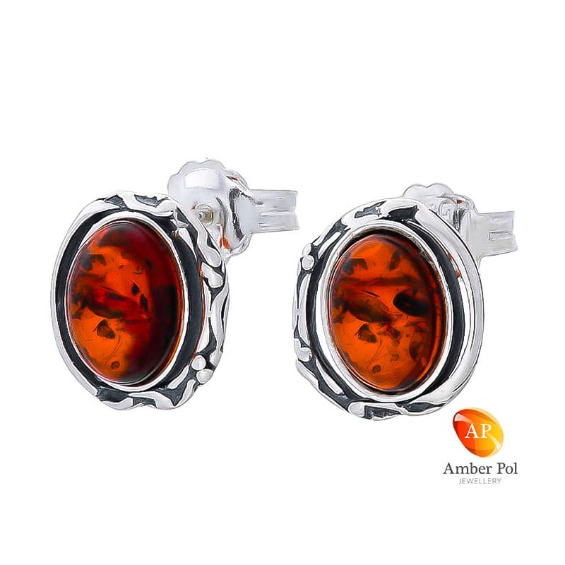 Piękne kolczyki ze srebra próby 925 na sztyft o owalnym kształcie z bocznymi zdobieniami i bursztynem  w kolorze koniakowym.