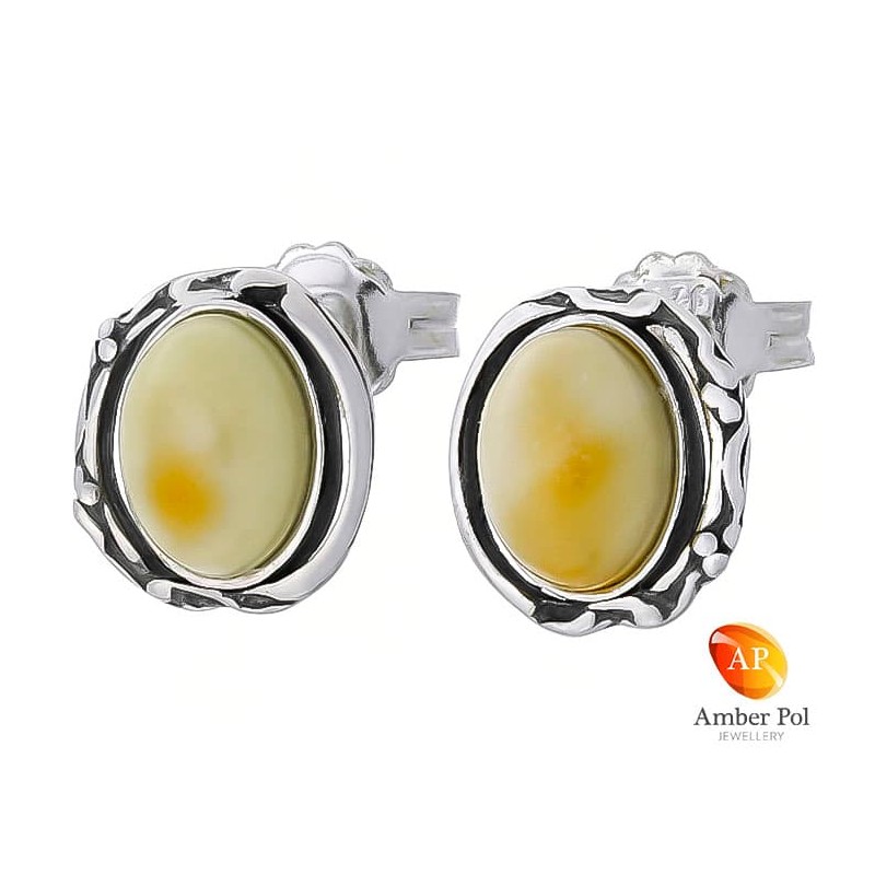 Piękne kolczyki ze srebra próby 925 na sztyft o owalnym kształcie z bocznymi zdobieniami i bursztynem  w białym kolorze.