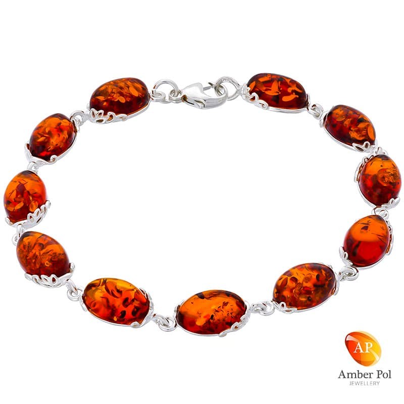 Piękna srebrna bransoletka próby 925 z 11 elementami i owalnymi  bursztynami w kolorze koniaku. zdobiona ażurkami.