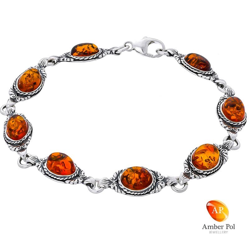 Bransoletka srebrna próby 925 z bursztynami w kolorze koniakowym. Posiada 8 elementów i delikatne zdobienie.