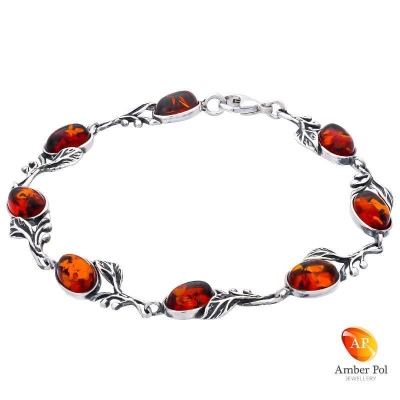 Piękna bransoletka ze srebra 925 zdobiona 8 elementami z owalnymi bursztynami w kolorze koniaku i listkami.