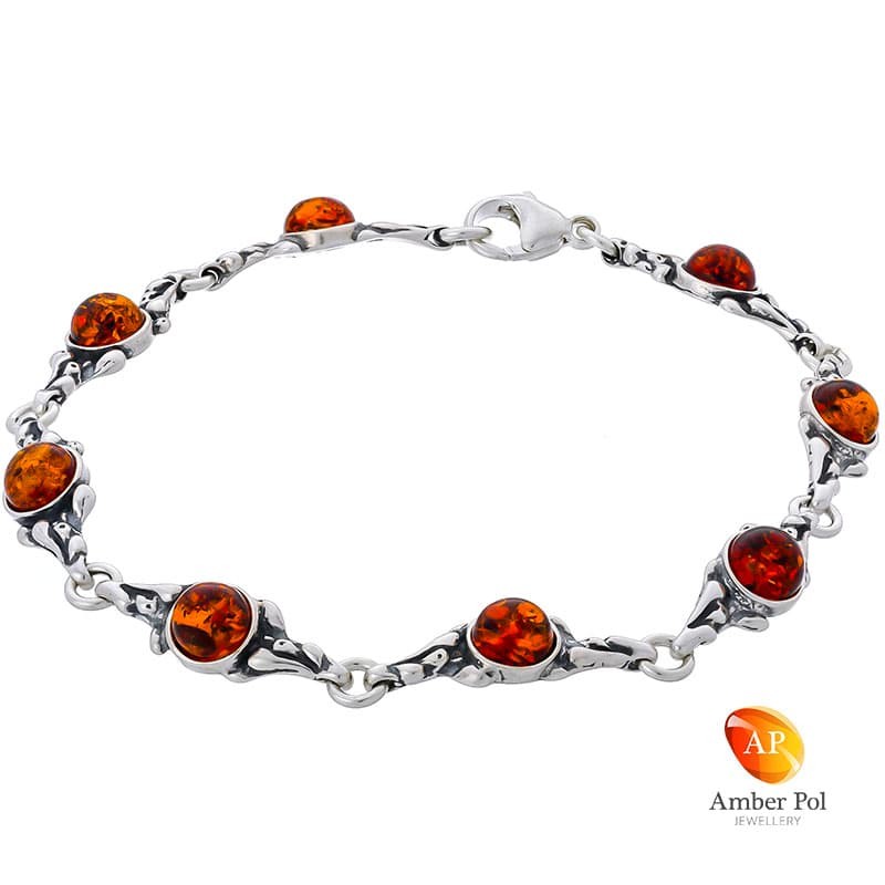 Bransoletka ze srebra 925 z okrągłymi bursztynkami w koniakowym kolorze. Ma 8 elementów i zdobienia jak kropelki wody.