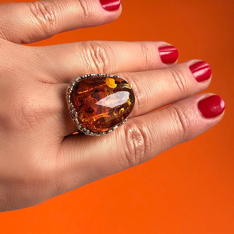 Piękny pierścionek ze srebra 925 z dużym koniakowym bursztynem w ażurowej oprawie.