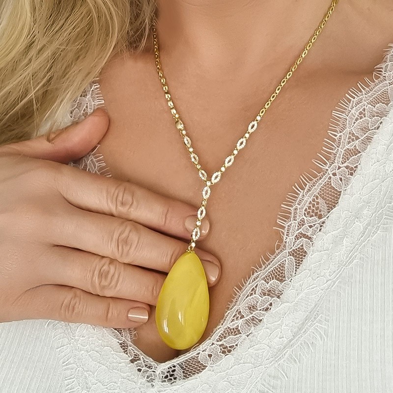 Pozłacany naszyjnik ze srebra 925 z cyrkoniami i dużym soplem z naturalnego bursztynu w  mlecznym kolorze.