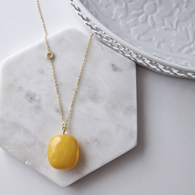 Naszyjnik srebrny 925 pozłocony 24-karatowym złotem z zawieszką z dużego naturalnego bursztynu w mlecznym kolorze.