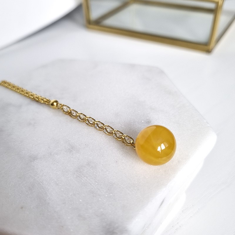 Naszyjnik ze srebra próby 925 pozłocony 24 karatowym złotem  i zawieszą z bursztynowej naturalnej kulki w mlecznym kolorze.