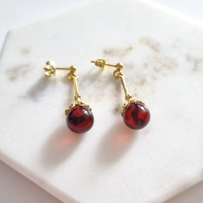 Kolczyki pozłacane z bursztynem wykonane ze srebra 925. Bursztyn w kolorze wiśniowym